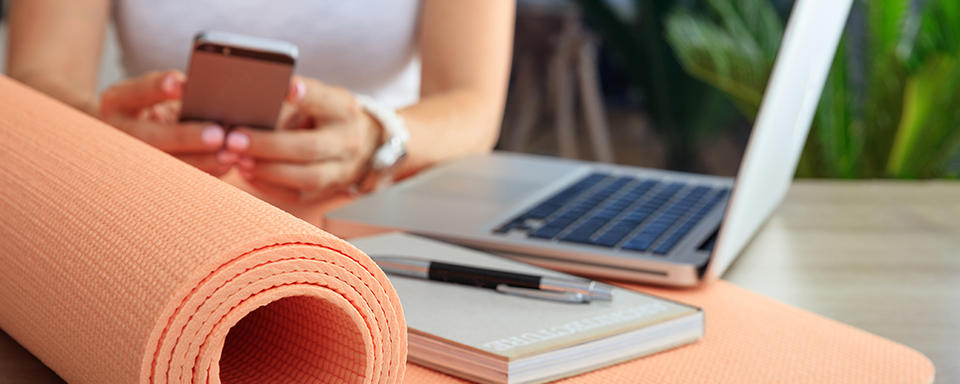 Persoon met yogamat zit aan bureau