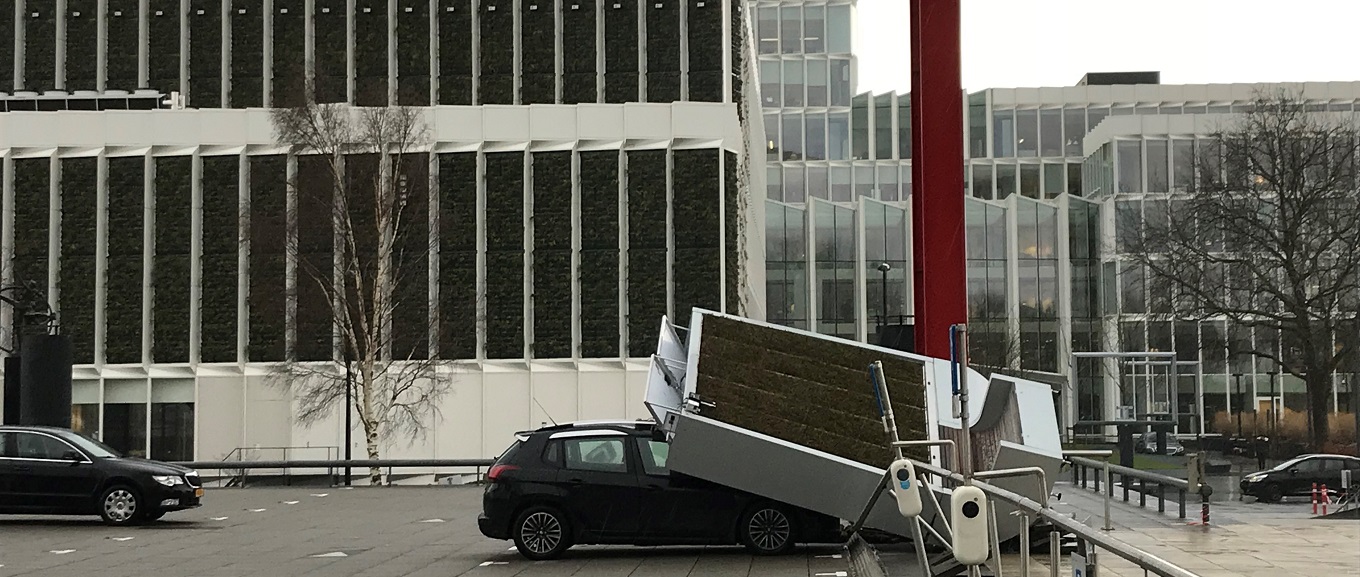 Stormschade aan een auto voor het a.s.r. gebouw. 