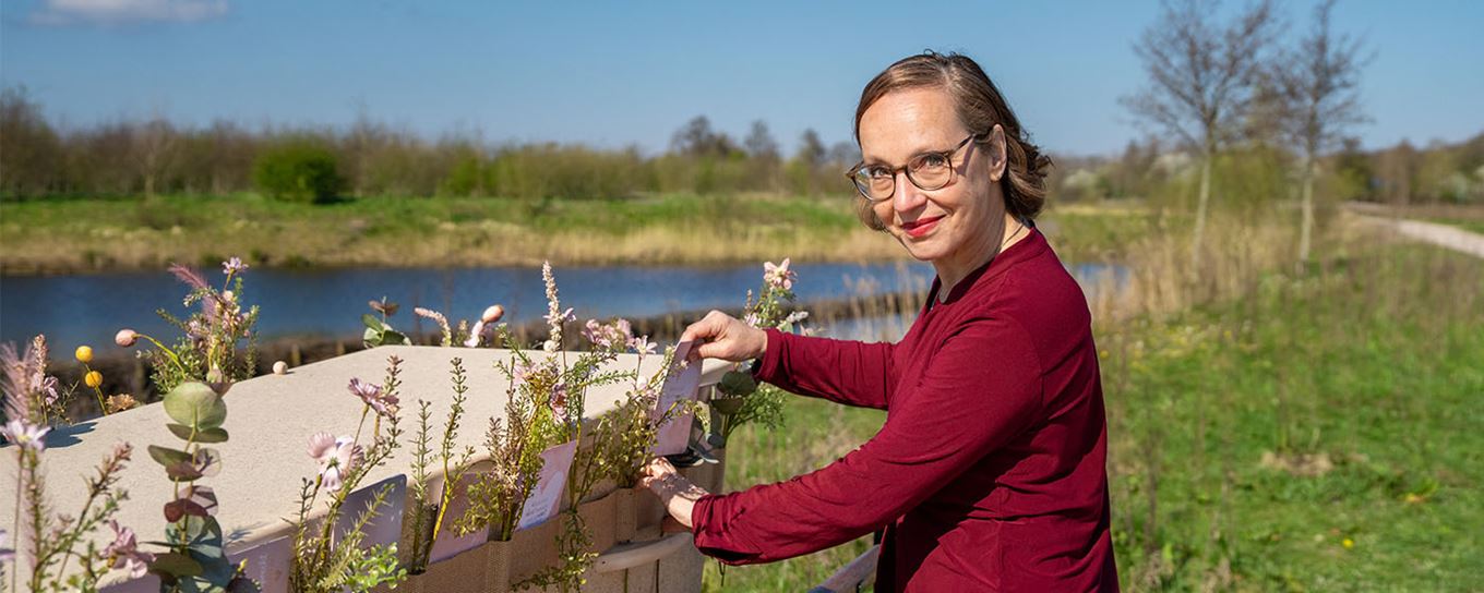Jantine bij een grafkist met een bloemenband eromheen
