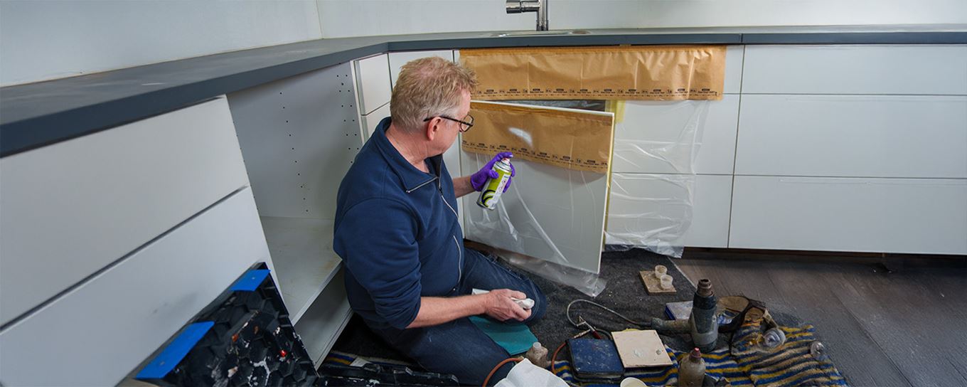 Een monteur is een keukenkast aan het herstellen