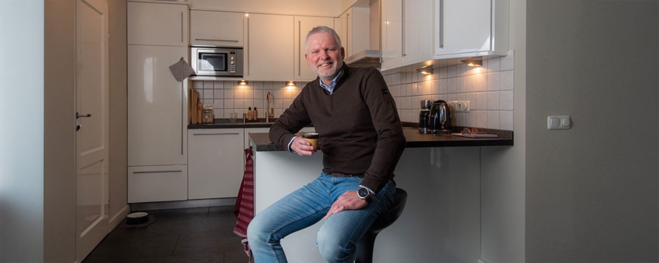 Harry van Putten zittend op een barkruk in een keuken