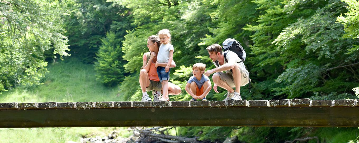 man en vrouw met 2 kinderen op een brug op vakantie