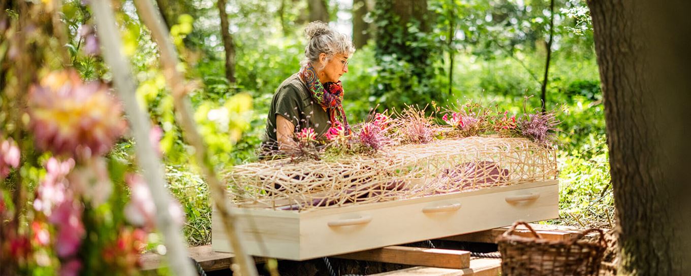 vrouw bij een grafkist midden in de bossen