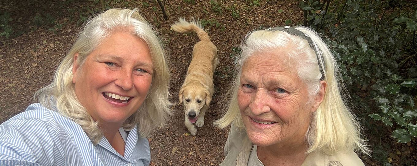 2 vrouwen lachend op de foto met hun goldenretriever