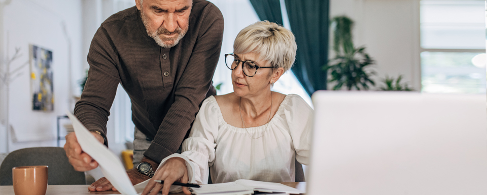 Echtpaar met papierwerk op bureau overleggen regelen verzekering online