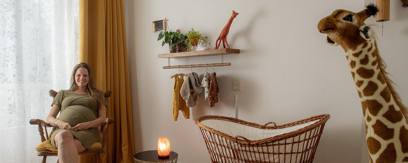 Afbeelding van een zwangere vrouw zittend in een babykamer