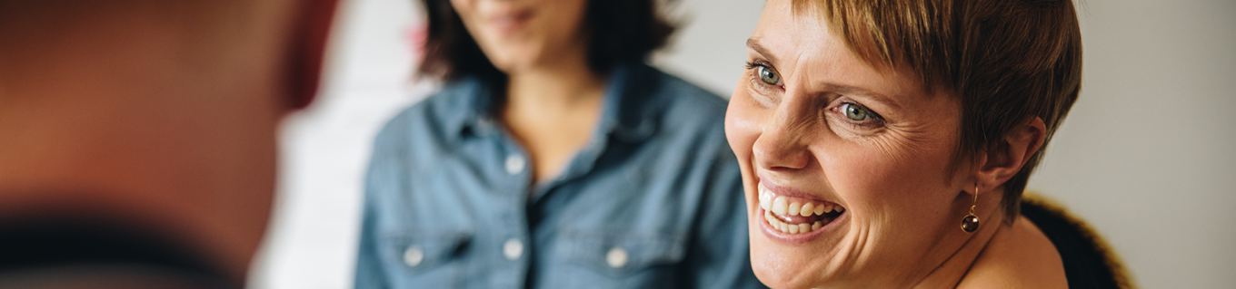 Vrouw lacht naar iemand in een groep | Doenpensioen | a.s.r.