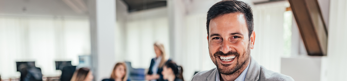 Man op kantoor lacht in de camera | Doenpensioen | a.s.r.