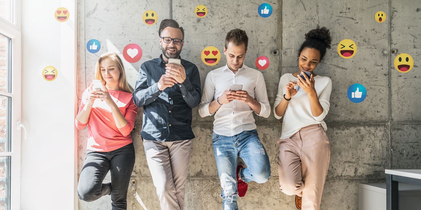 twee mannen en twee vrouwen staan tegen muur en gebruiken smartphones